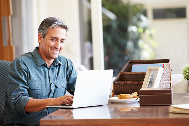 Man Smiling While Using Laptop Computer